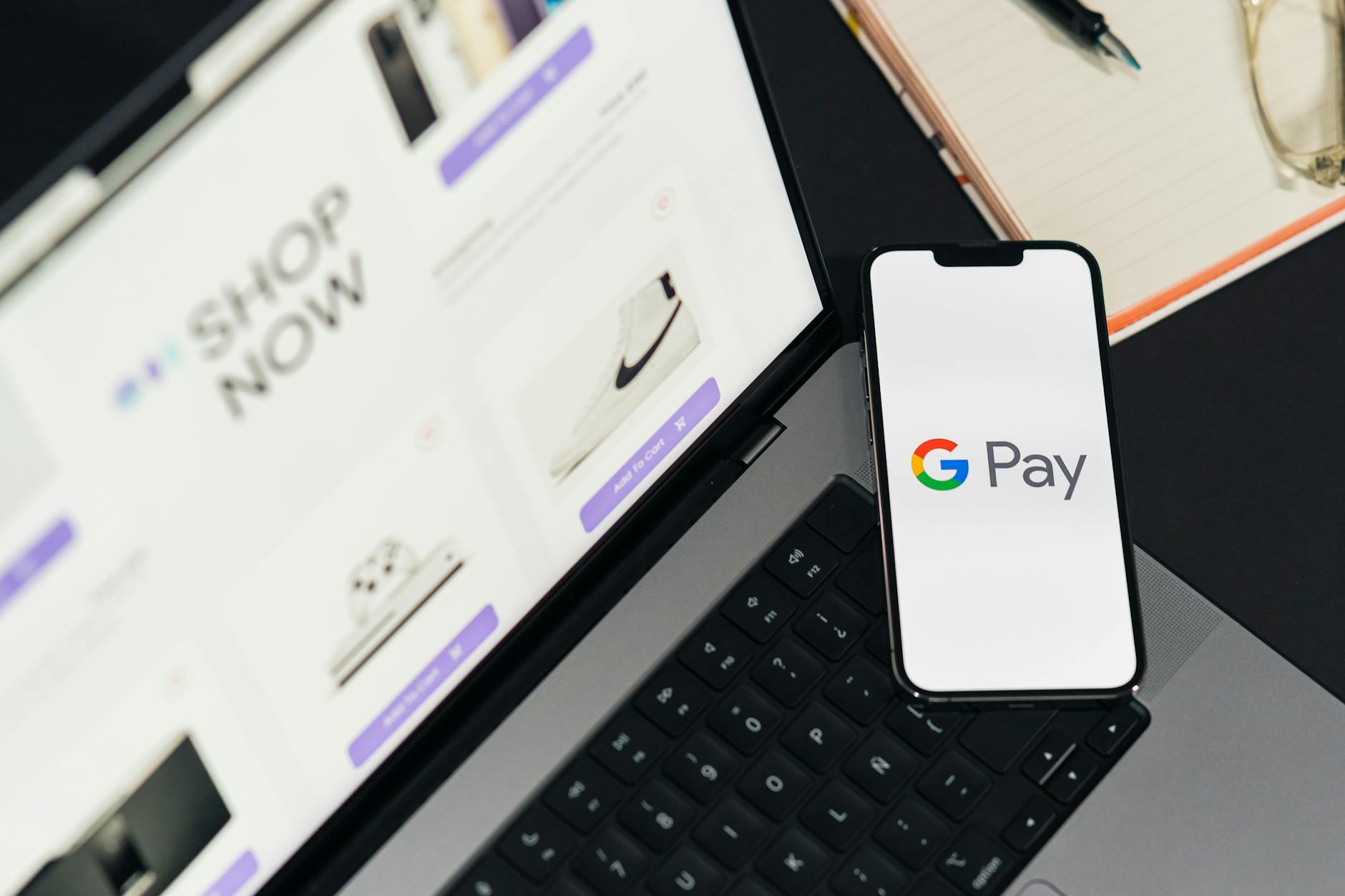 close-up of a smartphone showing a retail app purchase history screen next to a wallet and a neatly folded shirt on a wooden table