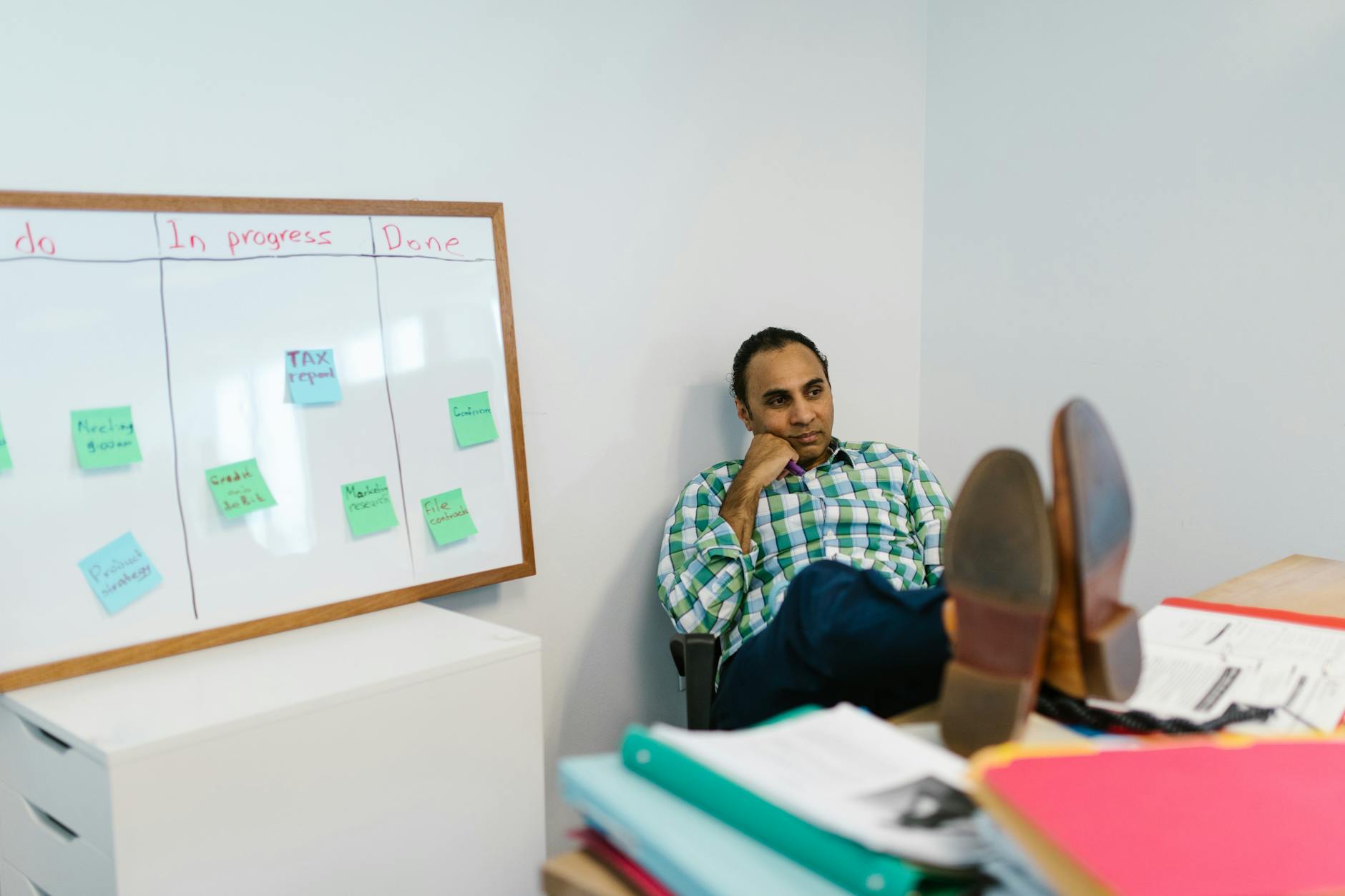 Which is the Best AI PM Tool?: Monday.com vs Asana vs ClickUp 2 colorful kanban board with status columns and a workload chart on a wall-mounted display in a team room
