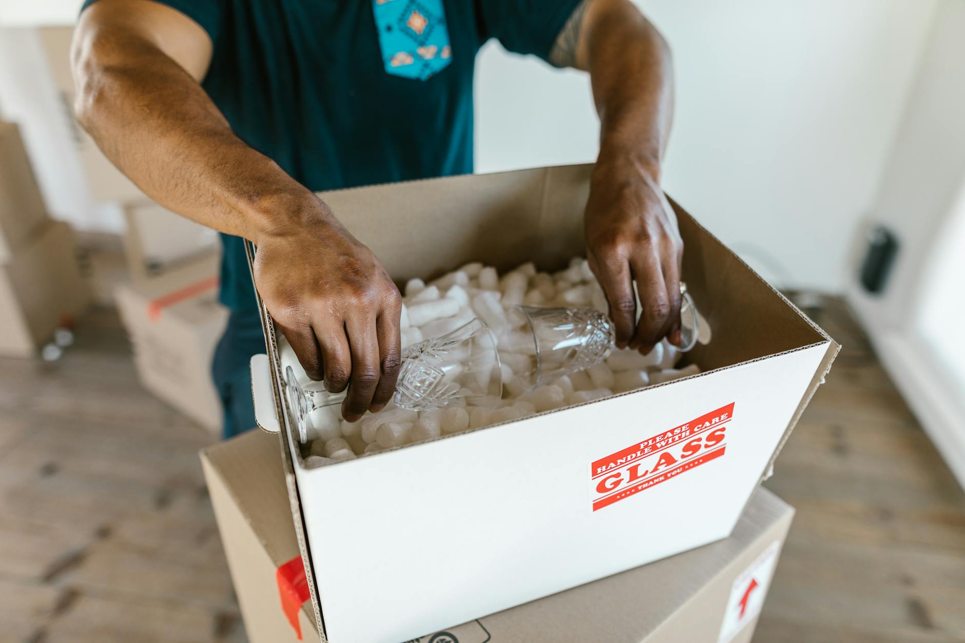 overhead photo of a neatly packed return box with bubble wrap, accessories arranged beside the item, and a printed label ready to apply