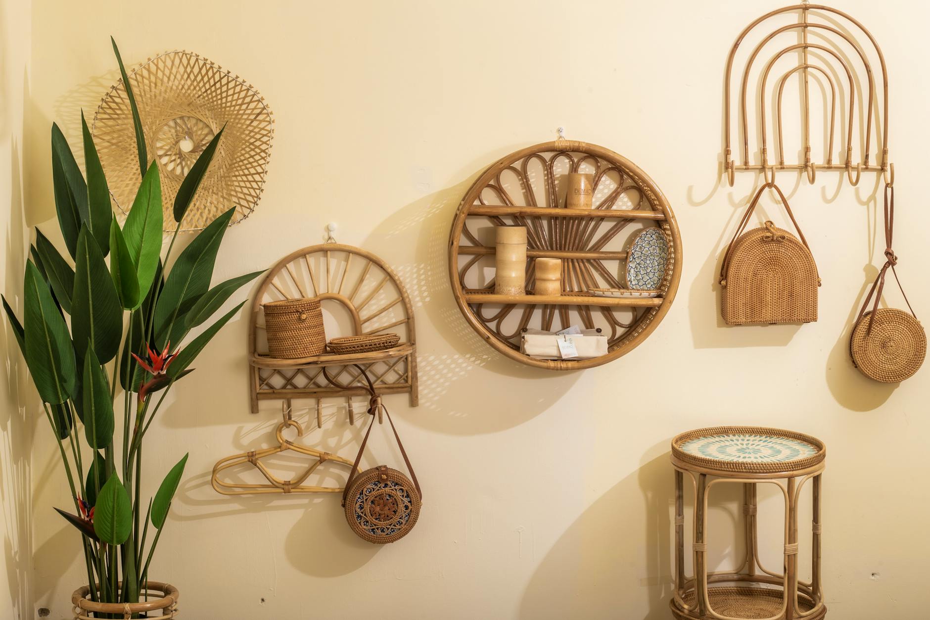 sunlit thrift boutique interior with tropical-print dresses, rattan furniture, and bright accessories arranged on white walls
